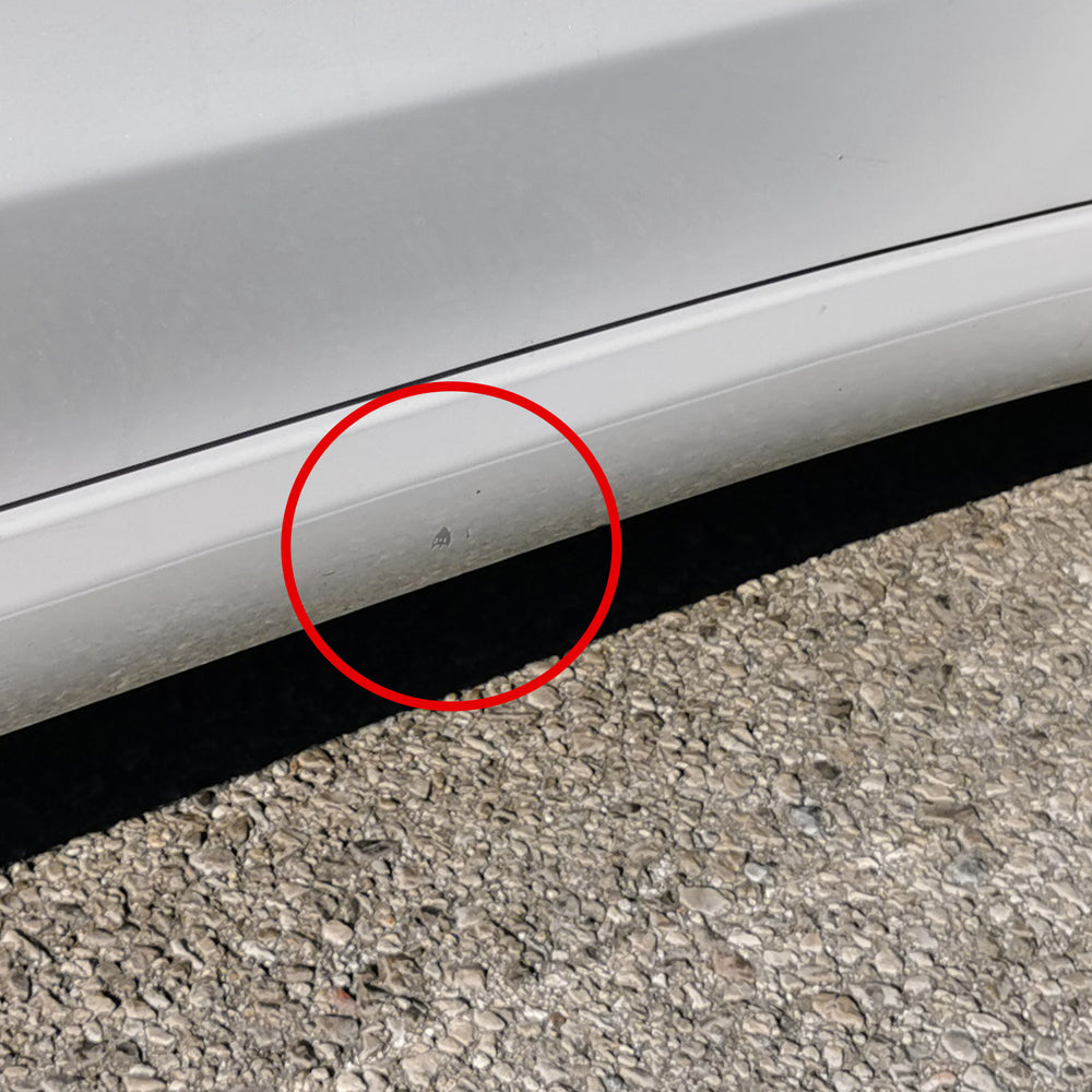 Dégât de peinture marqué en rouge sur la jupe latérale d’une Tesla Model 3 blanche