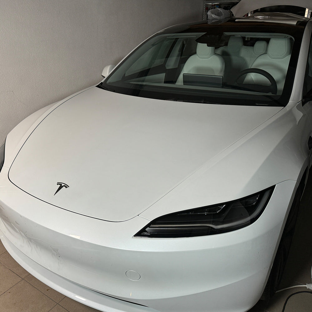 Tesla Model 3 « Highland » blanche vue de face dans l’atelier